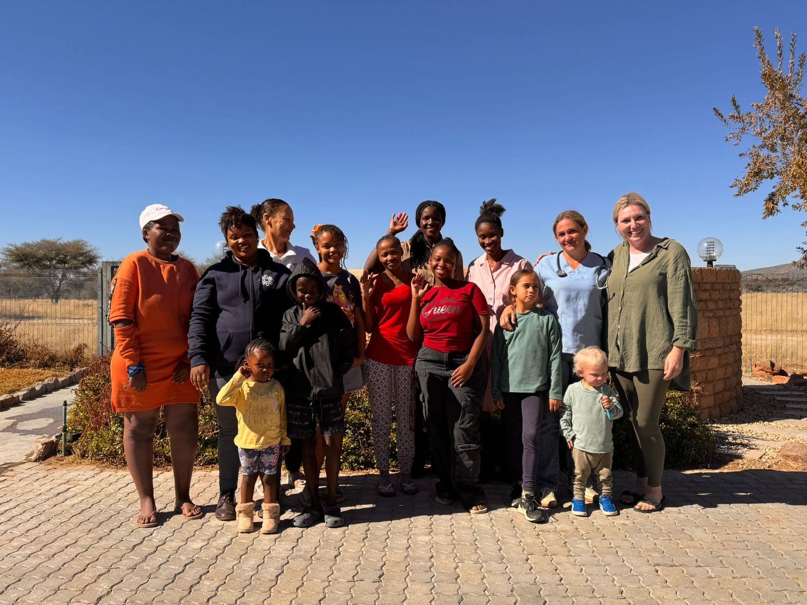 The families who live on the farm, with their children, Katharina Drescher, and the doctor in front of the farm office.